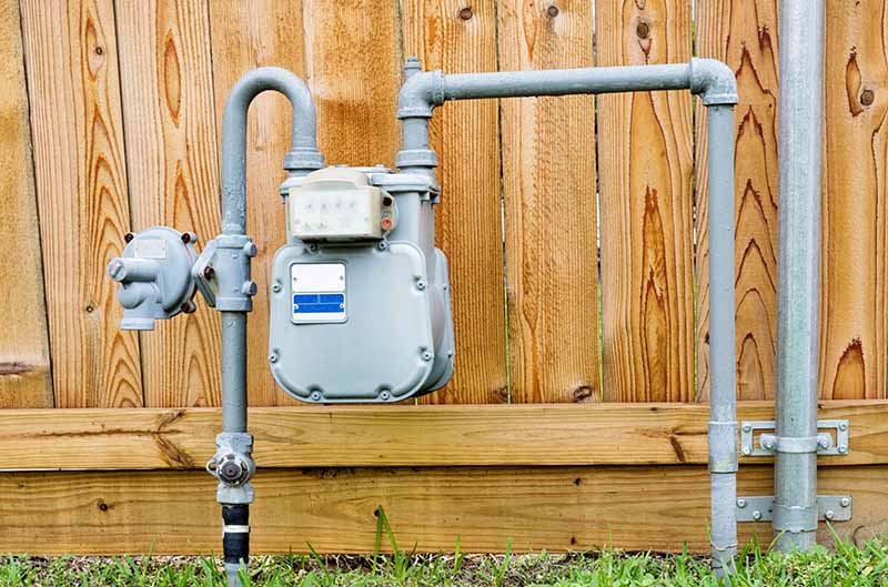 Residential Gas Meter and Pipe System Installed on Exterior residential gas meter and steel pipe system installed on home exterior