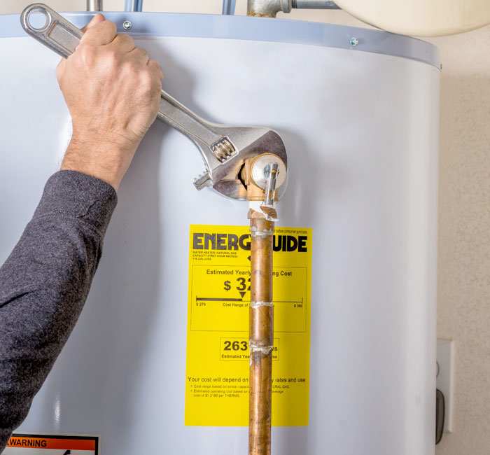 hot-water-heater plumber tightening kitchen faucet fitting at stainless sink with wrench