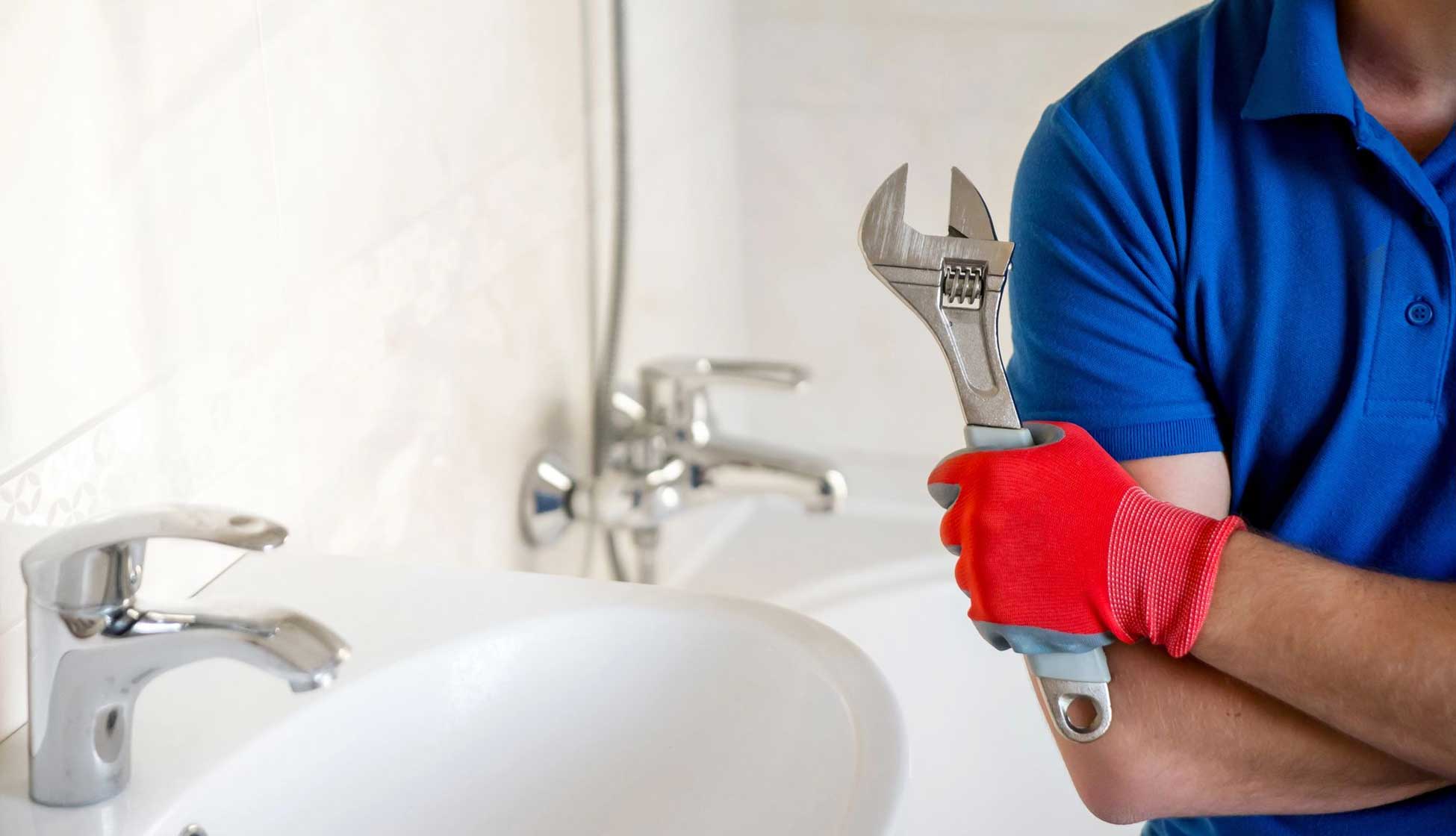 plumber in overalls servicing water softener system in utility room