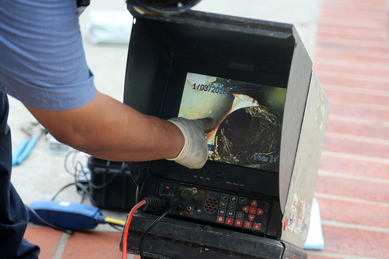 Sewer Camera Inspection Monitor Showing Pipe Interior plumber viewing sewer camera inspection monitor showing blocked pipe interior