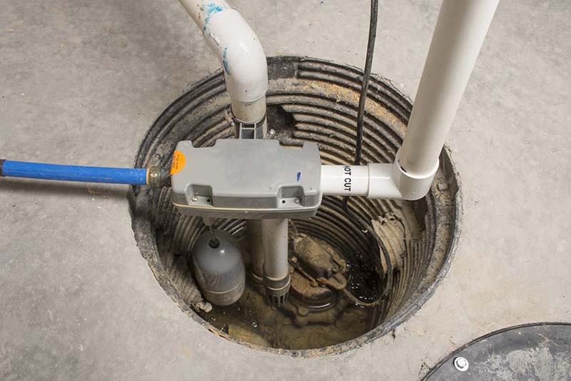 Sump Pump Installed in Basement Pit With Discharge Pipes sump pump installed in basement pit with pvc discharge pipes and float switch