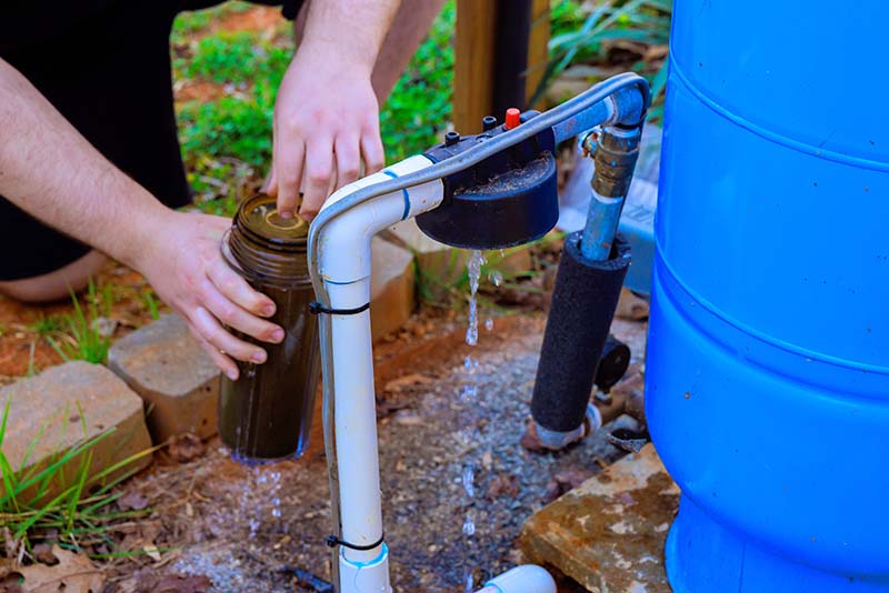 Plumber Installing Whole House Water Filter Housing plumber installing whole house water filter housing with pvc pipe connections