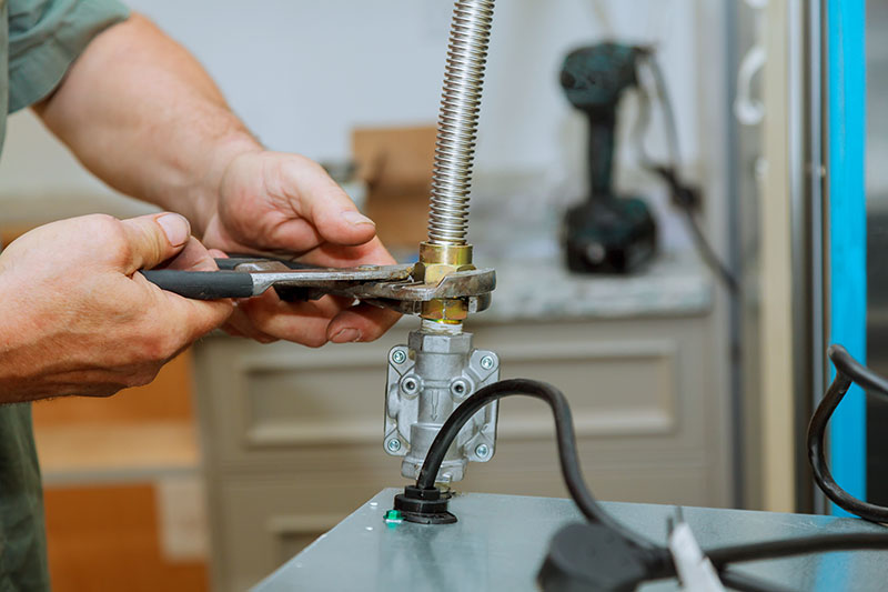 plumber connecting copper supply lines to new water heater top