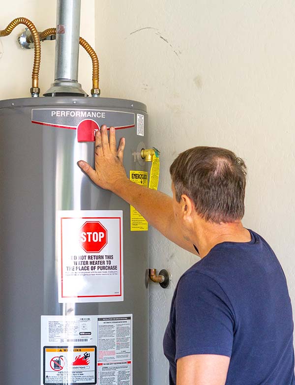 plumber inspecting residential water heater tank and expansion vessel