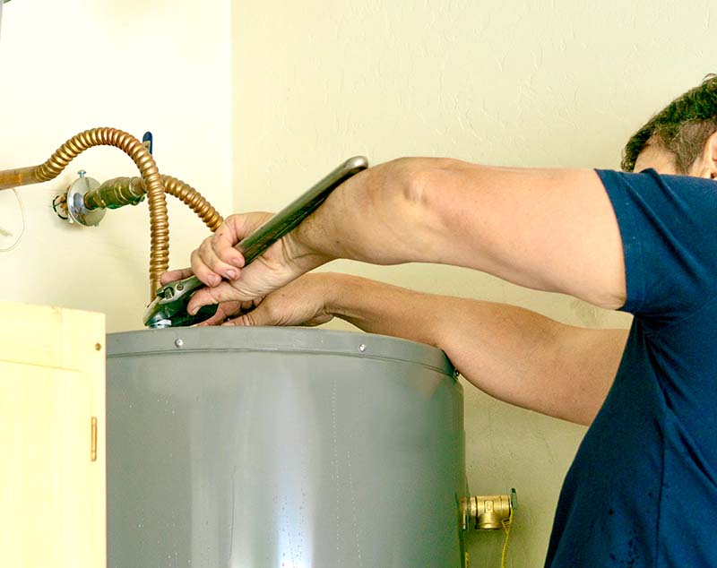 Water Heater Replacement Top Fitting With Wrench plumber using wrench to disconnect top fittings during water heater replacement